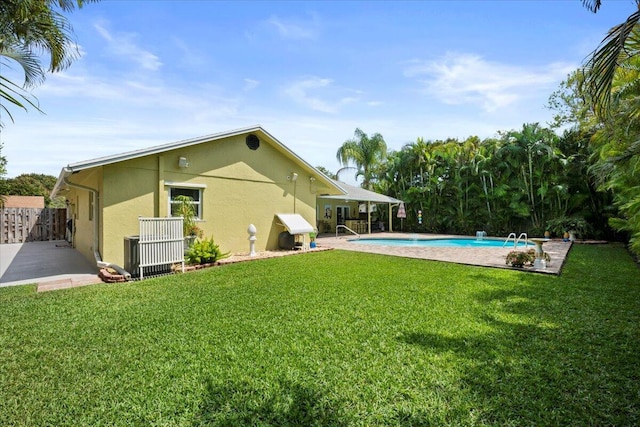 exterior space with a patio area, an outdoor pool, central AC, and fence