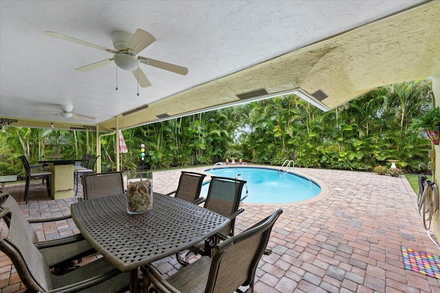 pool with outdoor dining space, a patio area, and ceiling fan