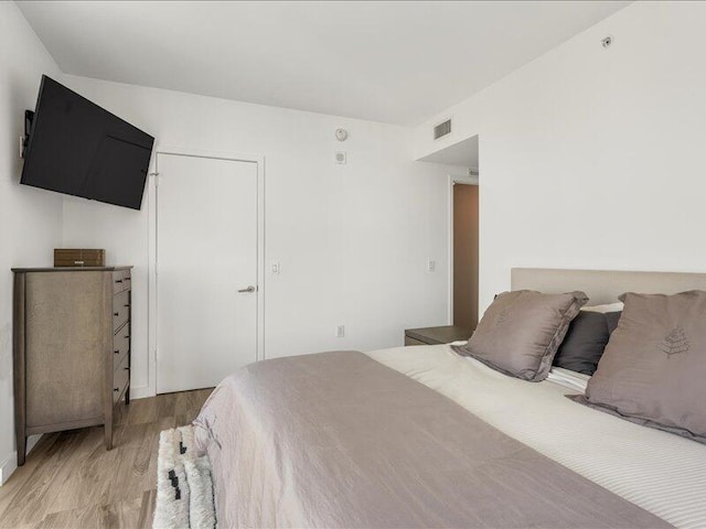 bedroom with light wood-style flooring and visible vents