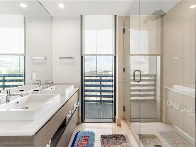 bathroom with tile patterned flooring, a stall shower, and a sink