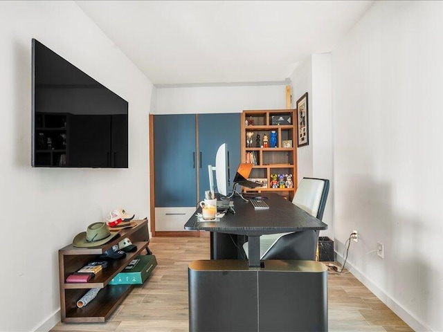 office area with light wood-style flooring and baseboards