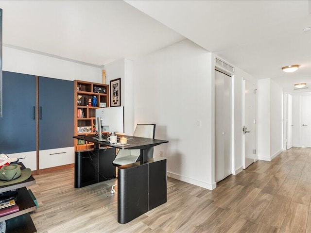 office space featuring baseboards and wood finished floors