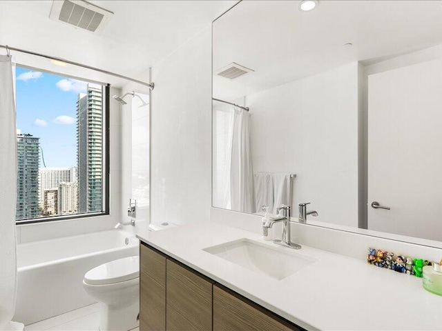 bathroom featuring vanity, a city view, toilet, and visible vents