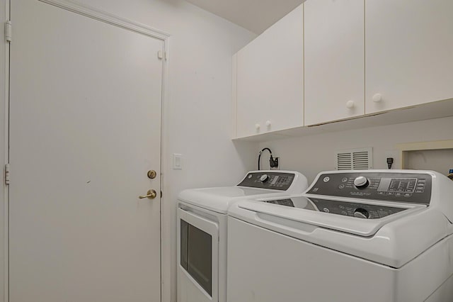 washroom featuring cabinet space and washing machine and dryer