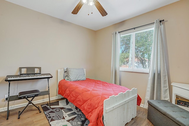 bedroom featuring a ceiling fan, wood finished floors, and baseboards