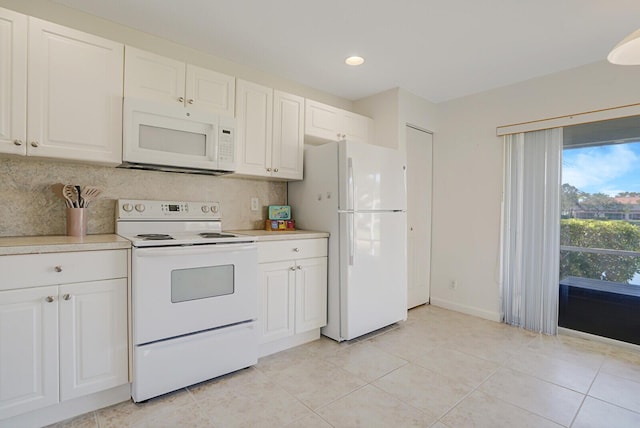 kitchen featuring tasteful backsplash, baseboards, light countertops, white cabinets, and white appliances