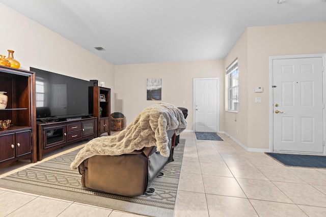 living area with light tile patterned floors, visible vents, and baseboards