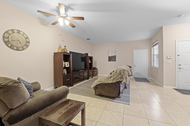 living room featuring light tile patterned floors, visible vents, baseboards, and a ceiling fan