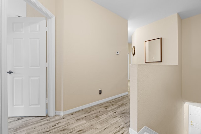 hallway with light wood-style flooring and baseboards