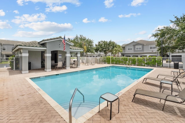 community pool featuring a patio area and fence