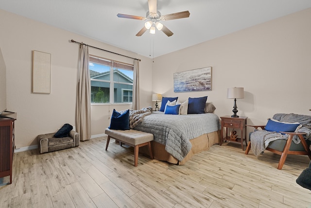 bedroom featuring light wood finished floors, baseboards, and a ceiling fan