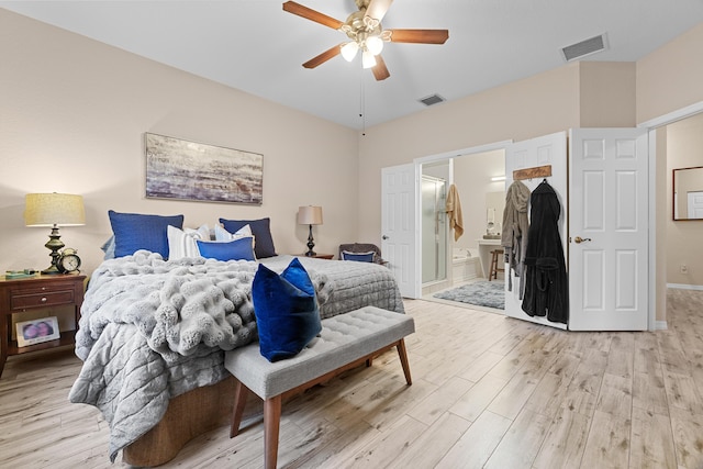 bedroom with visible vents, light wood-style floors, ceiling fan, and ensuite bathroom