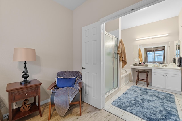 full bath featuring baseboards, a garden tub, a stall shower, and vanity