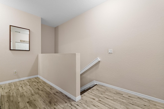 clothes washing area with baseboards and wood finished floors