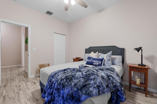 bedroom with a ceiling fan, visible vents, baseboards, light wood-style floors, and a closet