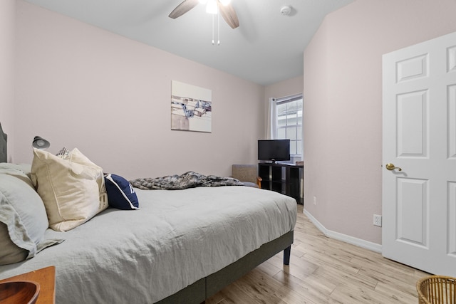 bedroom featuring baseboards, light wood-style floors, and a ceiling fan