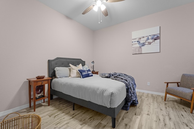 bedroom featuring light wood finished floors, ceiling fan, and baseboards