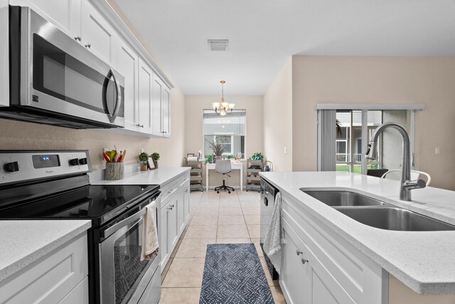 kitchen with visible vents, light tile patterned flooring, a notable chandelier, stainless steel appliances, and a sink