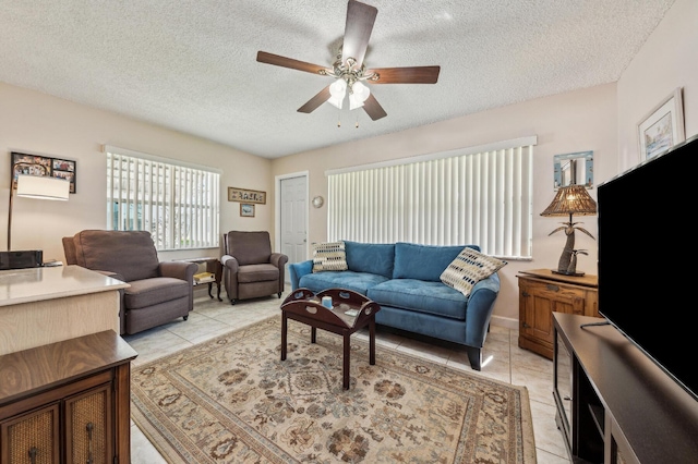 living area featuring light tile patterned floors, a textured ceiling, and a ceiling fan