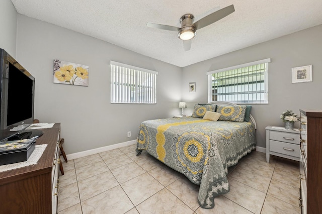 bedroom with multiple windows, light tile patterned floors, and a textured ceiling