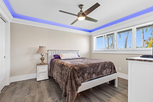 bedroom with multiple windows, wood finished floors, and baseboards