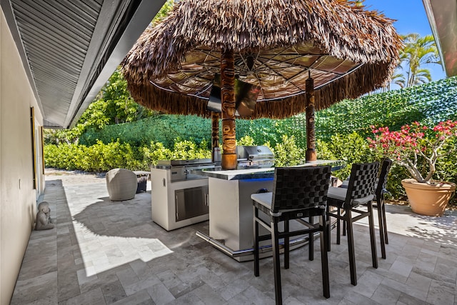 view of patio featuring an outdoor kitchen and a grill