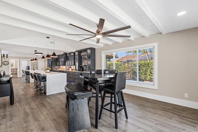 dining area featuring wood finished floors, a ceiling fan, baseboards, vaulted ceiling with beams, and recessed lighting