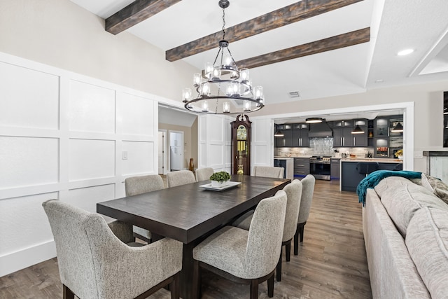 dining area with wood finished floors, beam ceiling, recessed lighting, a decorative wall, and a chandelier