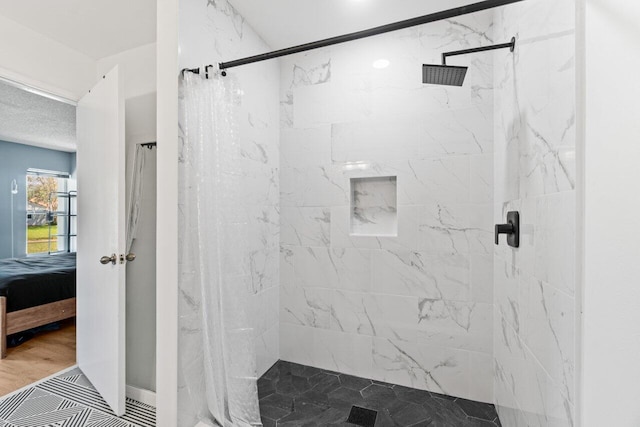 ensuite bathroom with wood finished floors, a marble finish shower, and ensuite bathroom