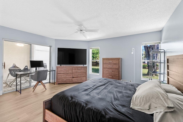 bedroom with a textured ceiling, light wood-type flooring, and ceiling fan