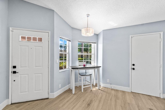 entryway featuring wood finished floors, baseboards, and a textured ceiling