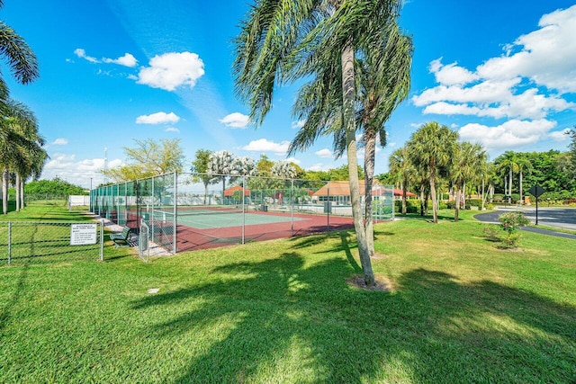 view of sport court with a yard and fence