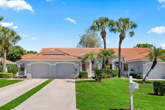 mediterranean / spanish-style house with stucco siding, driveway, a front yard, a garage, and a tiled roof