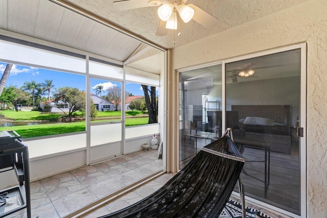 sunroom featuring lofted ceiling and a ceiling fan