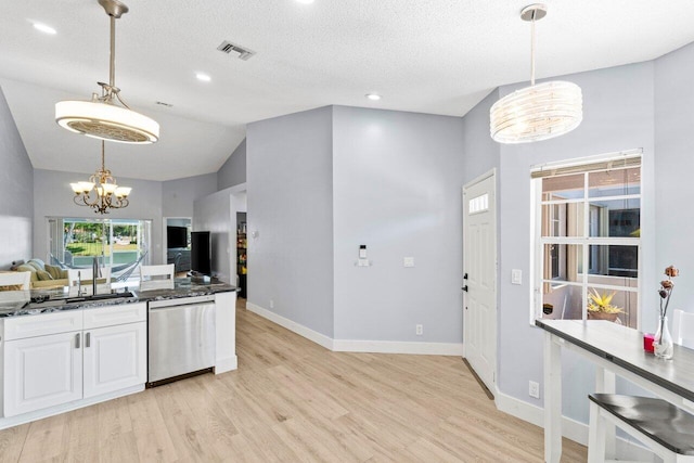 kitchen featuring a chandelier, light wood-style flooring, stainless steel dishwasher, white cabinetry, and a sink