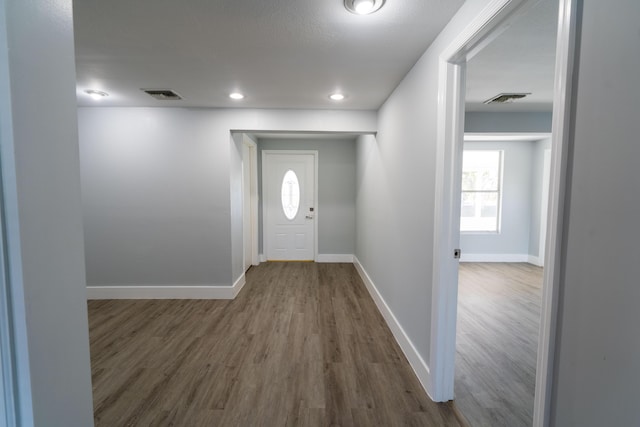 foyer entrance featuring recessed lighting, visible vents, baseboards, and wood finished floors