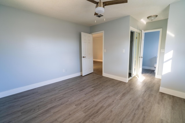 unfurnished bedroom with visible vents, ceiling fan, baseboards, wood finished floors, and a textured ceiling
