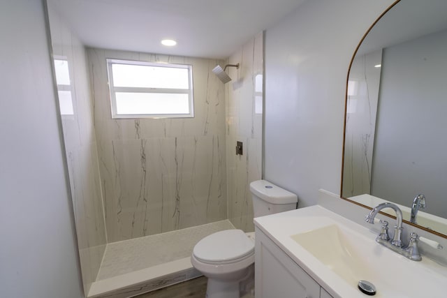 bathroom featuring a marble finish shower, toilet, and vanity