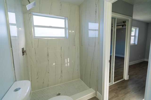 bathroom featuring a marble finish shower, visible vents, baseboards, toilet, and wood finished floors