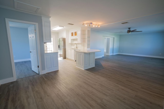 kitchen featuring a ceiling fan, dark wood-style flooring, light countertops, white cabinets, and stainless steel fridge