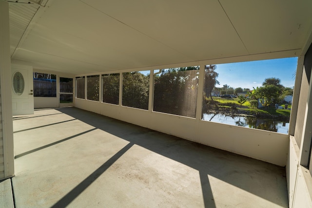unfurnished sunroom featuring a water view