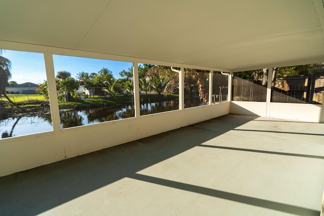 unfurnished sunroom featuring a water view