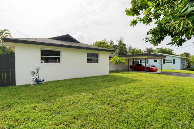 exterior space featuring a carport, fence, and driveway