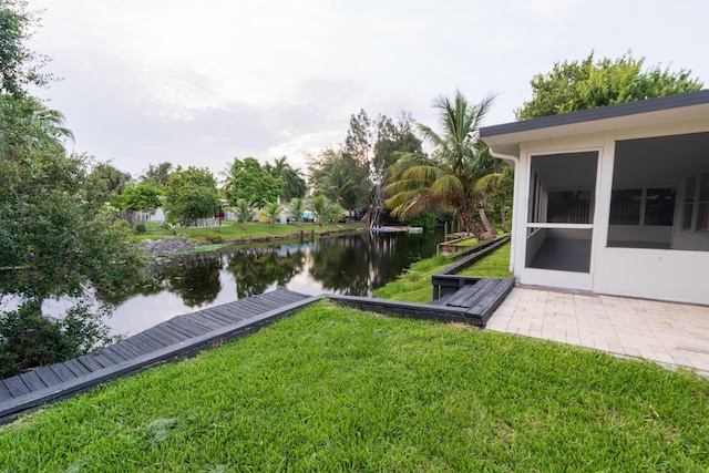 view of yard featuring a water view and a sunroom
