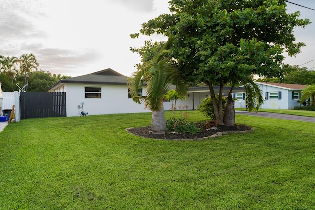 view of yard with driveway and fence