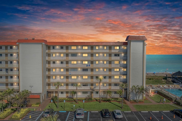 view of building exterior featuring a water view and uncovered parking