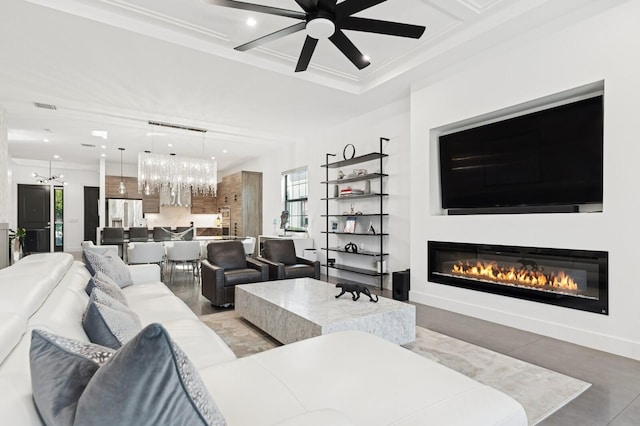 living area featuring recessed lighting, visible vents, a glass covered fireplace, and ceiling fan with notable chandelier