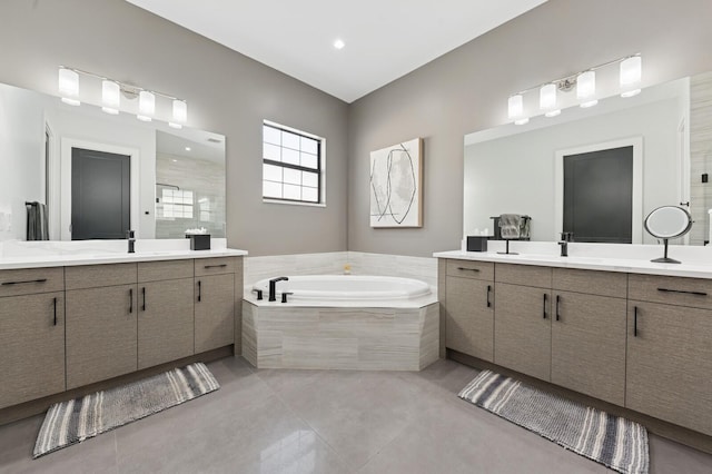 full bath with a sink, two vanities, a bath, and tile patterned floors