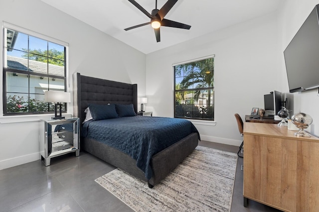 bedroom with a ceiling fan, finished concrete flooring, and baseboards