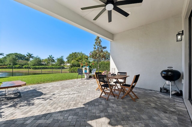 view of patio featuring outdoor dining area, area for grilling, ceiling fan, and fence